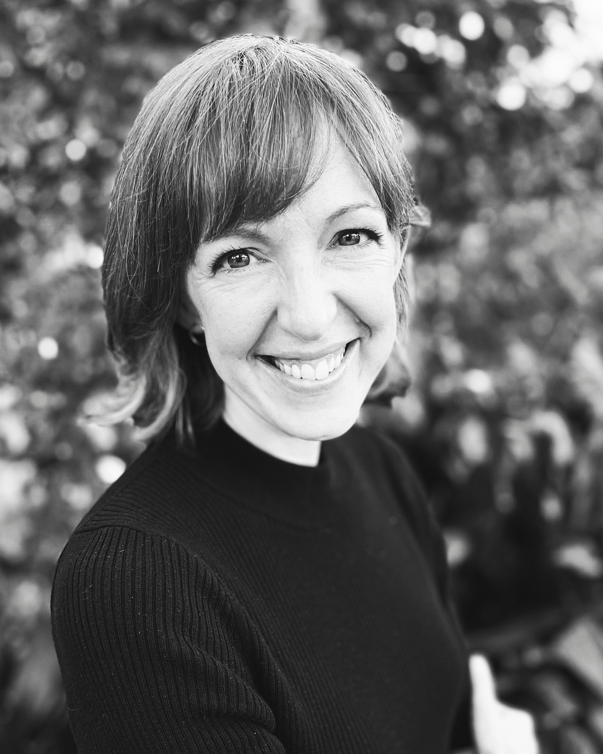 Black-and-white portrait of Susanna B. Klingenberg smiling outdoors